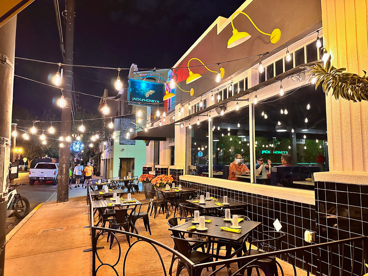 front of restaurant with sign and outside seating